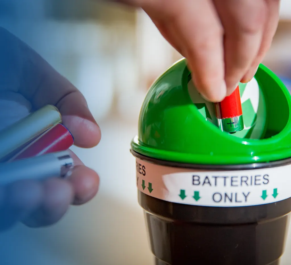 Alte leere Batterien werden in einen Batterien Sammelbehälter gegeben.